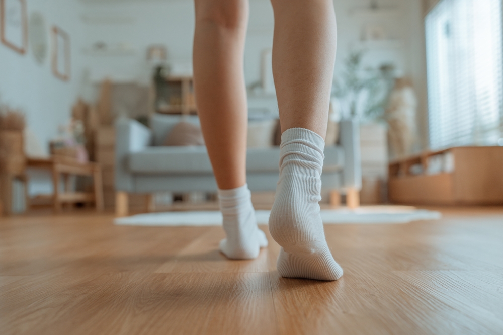 Girl walking on brown wooden flooring.