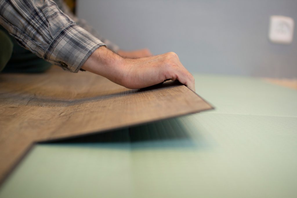 Professional laying wood-effect LVT (Luxury Vinyl Tiles) flooring during installation in Tunbridge Wells.