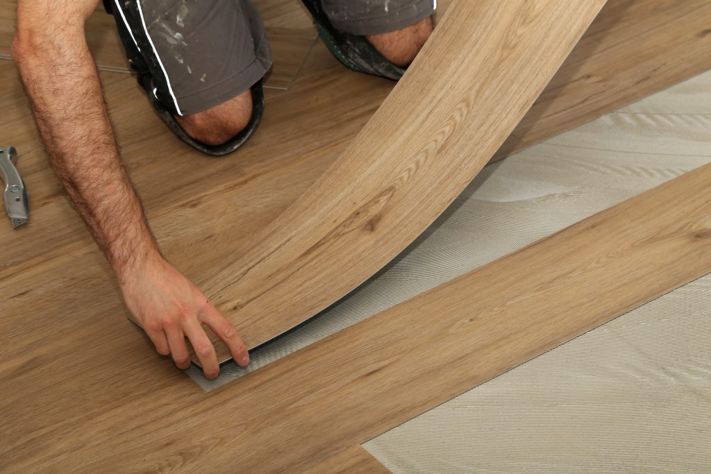 Installer fitting light oak LVT (Luxury Vinyl Tiles) flooring in a Tunbridge Wells home.