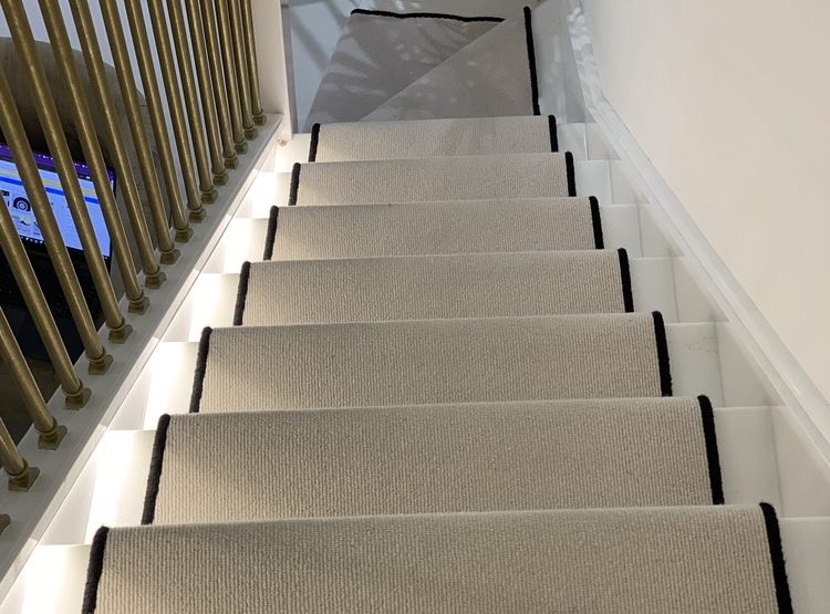 Pale stair runner with a black bound border fitted on a staircase in a Tunbridge Wells home